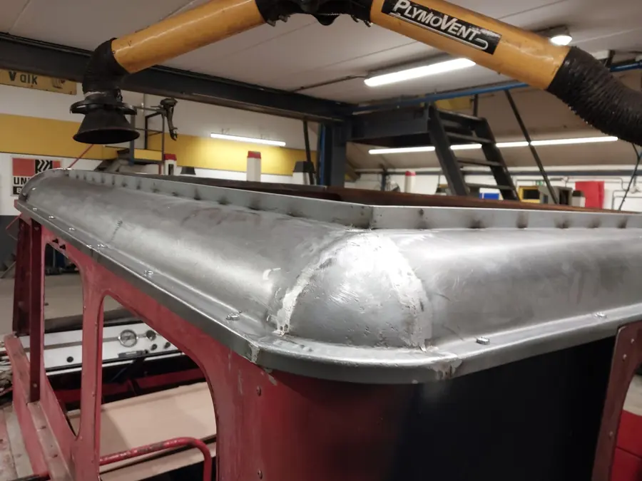Het aluminium dak op de rode cabine in de werkplaats
